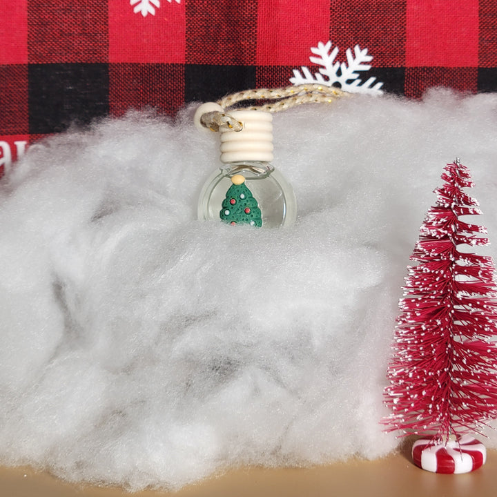 Close-up of a Santa Claus figure with a Christmas tree ornament on a red and black checkered background.