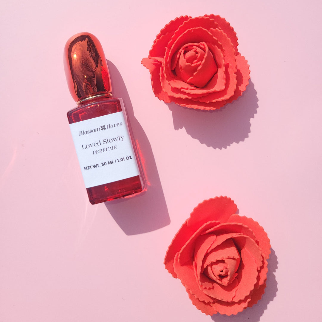 Red dropper bottle with a white label on a pink background with red flowers.