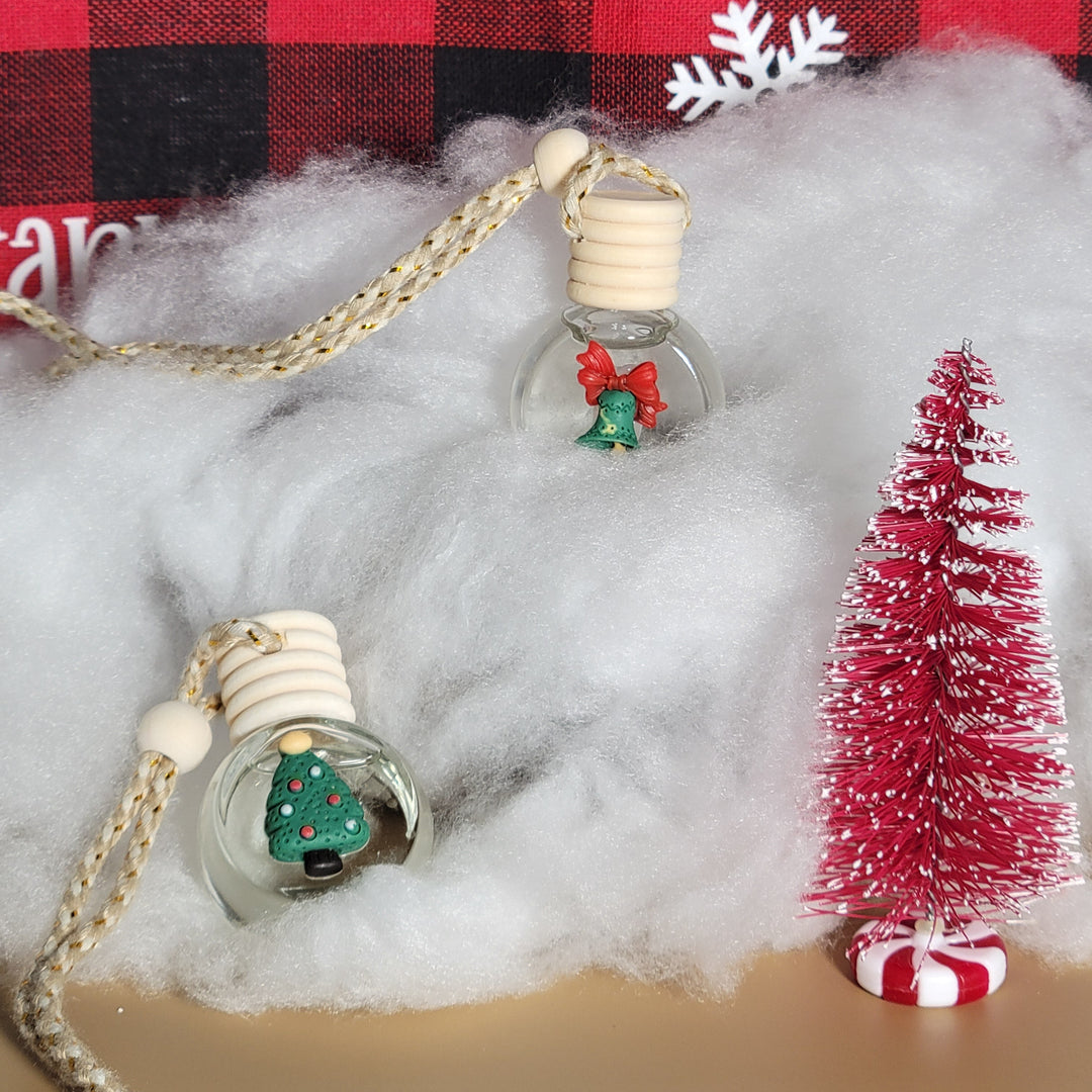 Christmas-themed earbud covers with tree and snowflake designs on a red and black checkered fabric background.